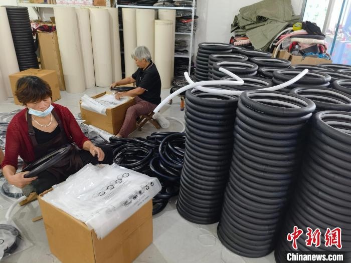 圖為村民在汽車飾品企業(yè)生產(chǎn)車間中工作?！巫雍?攝