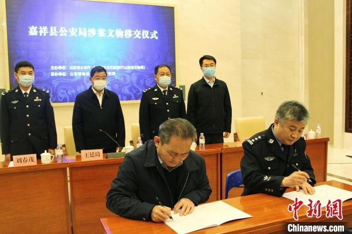 山東博物館館長(zhǎng)鄭同修和嘉祥縣人民政府副縣長(zhǎng)、公安局局長(zhǎng)趙健簽署移交協(xié)議?！≮w曉 攝