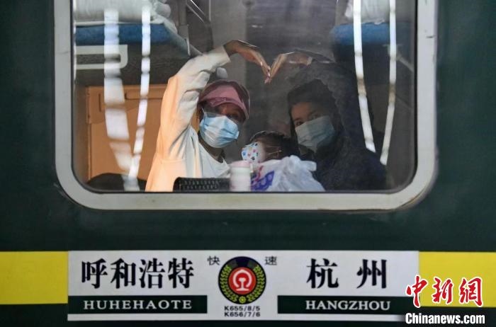 圖為登上轉(zhuǎn)運(yùn)火車的游客向額濟(jì)納比心?！⊥趵?攝