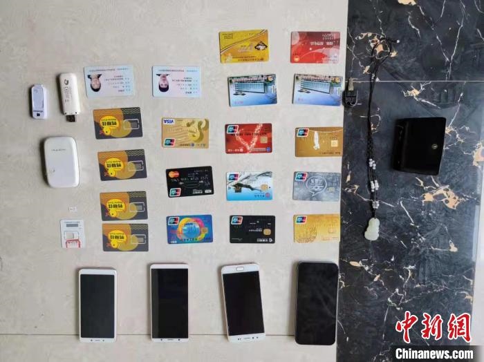 資料圖為果洛藏族自治州公安民警查扣的作案手機(jī)和涉案銀行卡?！‖斍呖h公安局供圖