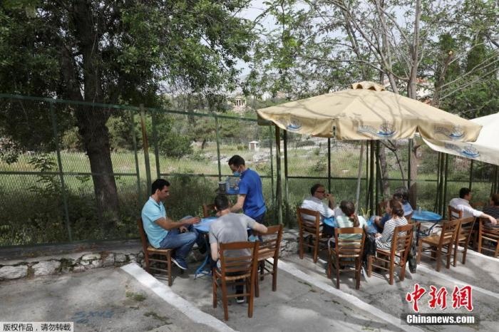 資料圖：希臘雅典，人們在一家露天咖啡享用飲品。