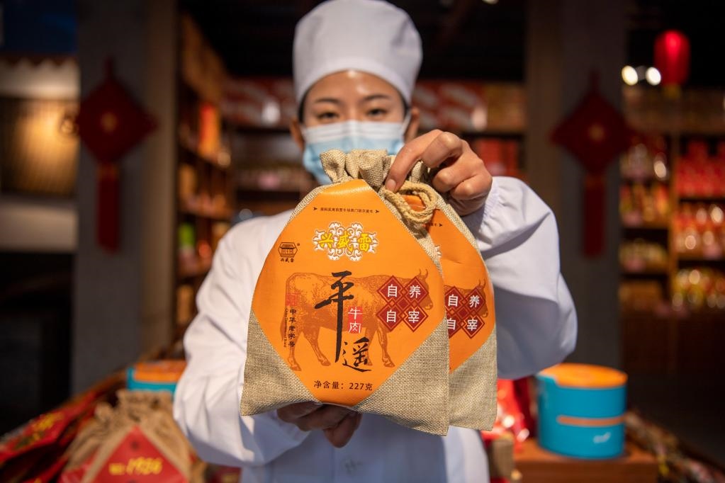 1月27日，在平遙古城南大街的一家平遙牛肉店內(nèi)，工作人員展示一款牛肉產(chǎn)品。新華社記者 楊晨光 攝