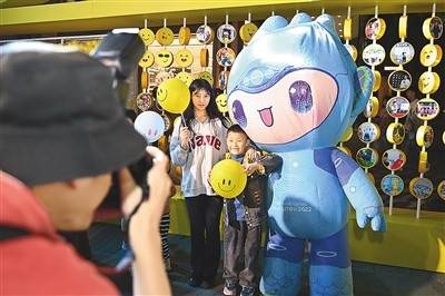 5月7日，在浙江省杭州市湖濱步行街“3D笑臉墻”前，攝影師為游客與杭州亞運(yùn)會(huì)吉祥物之一“宸宸”拍攝合影。