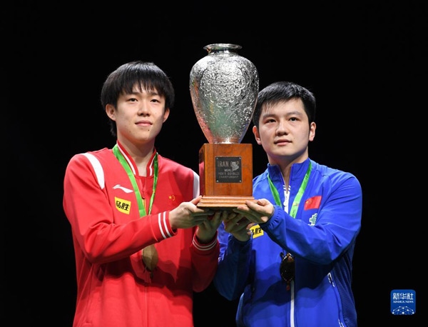 5月27日，樊振東（右）/王楚欽在頒獎(jiǎng)儀式上高舉獎(jiǎng)杯慶祝。當(dāng)日，在南非德班進(jìn)行的2023年世界乒乓球錦標(biāo)賽男雙決賽中，中國(guó)組合樊振東/王楚欽以3比0戰(zhàn)勝韓國(guó)組合張禹珍/林鐘勛，奪得冠軍。新華社記者 李亞輝攝