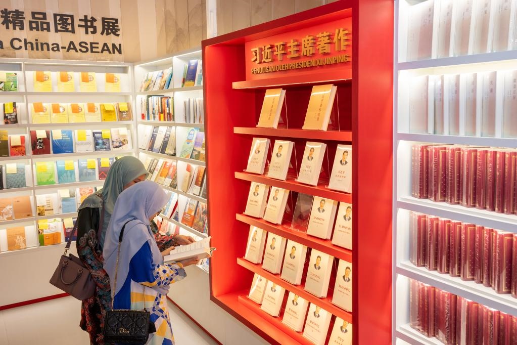 5月30日，兩名讀者在馬來(lái)西亞吉隆坡國(guó)際書(shū)展中國(guó)主賓國(guó)活動(dòng)現(xiàn)場(chǎng)閱讀習(xí)近平主席著作。新華社記者朱煒攝