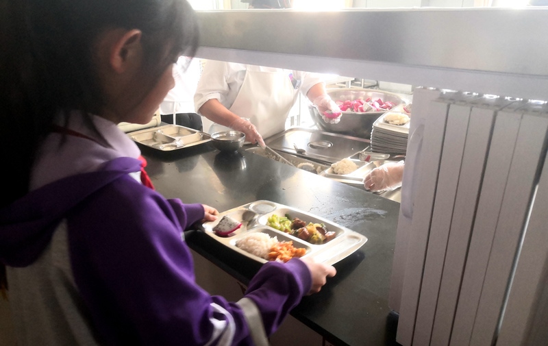 伊金霍洛旗第一小學學生正在打飯，今天的飯菜是三菜一湯外加水果，學生可以多次盛取，吃飽為止。人民網(wǎng)記者 孫博洋攝