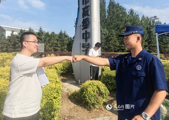 6月7日，遼寧營口老邊區(qū)消防救援大隊的消防員為高考學子加油助威。人民網(wǎng)記者 尹柏寒攝