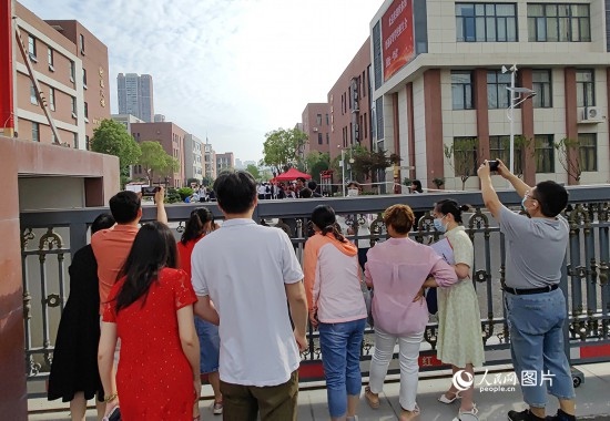 6月7日，武漢市第三中學考點，考生進場后，家長在柵欄外用手機拍攝自己的孩子。人民網(wǎng)記者 郭婷婷攝