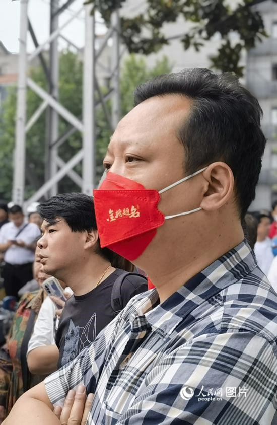 6月7日早，在武漢市第二十六中學考點外，送考家長戴著印有“金榜題名”的口罩。人民網(wǎng) 周雯攝