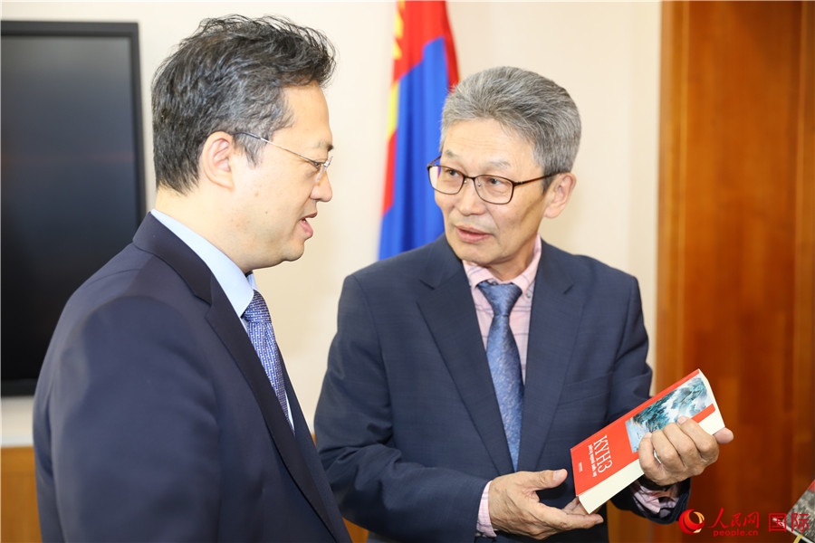 其米德策耶（右一）向李峙介紹翻譯成果。人民網(wǎng)記者 霍文攝