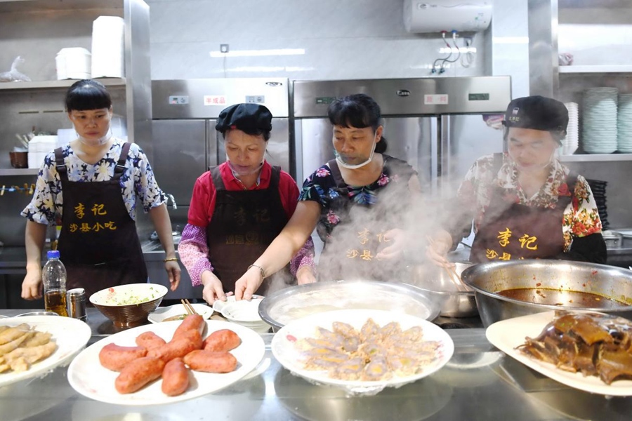 福建三明市沙縣區(qū)一家小吃店工作人員在為客人準(zhǔn)備特色小吃。 新華社記者 林善傳 攝