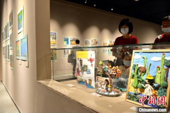 圖為家長帶著孩子參觀展覽。呂明 攝