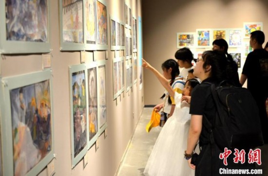 圖為家長帶著孩子參觀展覽。呂明 攝