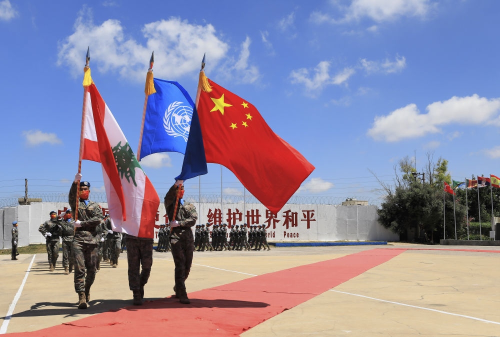 在黎巴嫩南部辛尼亞村的中國維和部隊營區(qū)，中國維和部隊官兵在受勛后通過觀禮臺（2022年7月1日攝）。聯(lián)合國駐黎巴嫩臨時部隊（聯(lián)黎部隊）當(dāng)日授予中國第20批赴黎巴嫩維和部隊全體410名官兵聯(lián)合國“和平勛章”，以表彰他們?yōu)槔璋湍勰喜康貐^(qū)和平穩(wěn)定作出的突出貢獻(xiàn)。新華社記者 劉宗亞 攝