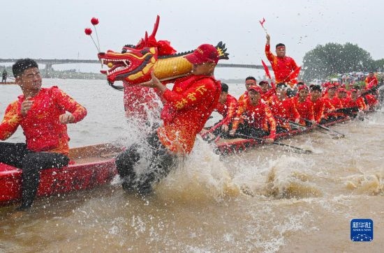 6月22日，在湖南省岳陽(yáng)市湘陰縣湘江臨資口水域，參加龍舟賽的隊(duì)員接“龍頭”下水。