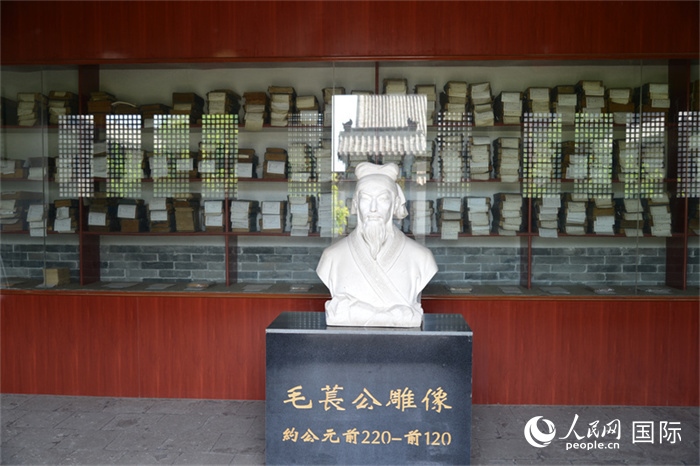 河間詩(shī)經(jīng)齋毛萇雕像。雕像后書(shū)櫥中陳列的是歷代各版本《詩(shī)經(jīng)》及譯本。 人民網(wǎng) 趙昭攝