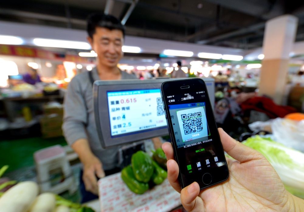 在河北省邯鄲市一家便民市場(chǎng)，消費(fèi)者在掃碼支付購買蔬菜（2018年6月3日攝）。新華社記者 王曉 攝