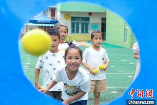 在肥西縣山南鎮(zhèn)中心幼兒園，孩子們在玩布洞投球游戲。陳家樂 攝