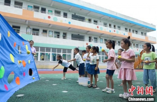 在肥西縣山南鎮(zhèn)中心幼兒園，孩子們在玩布洞投球游戲。陳家樂 攝