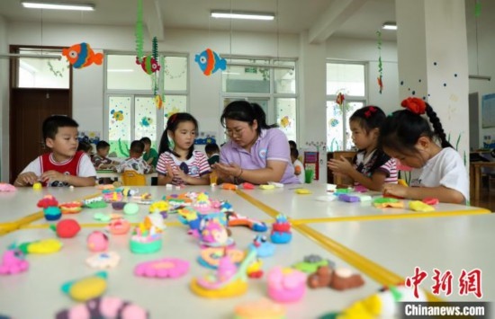 在肥西縣山南鎮(zhèn)中心幼兒園，孩子們在老師的指導(dǎo)下做彩色泥塑。陳家樂 攝