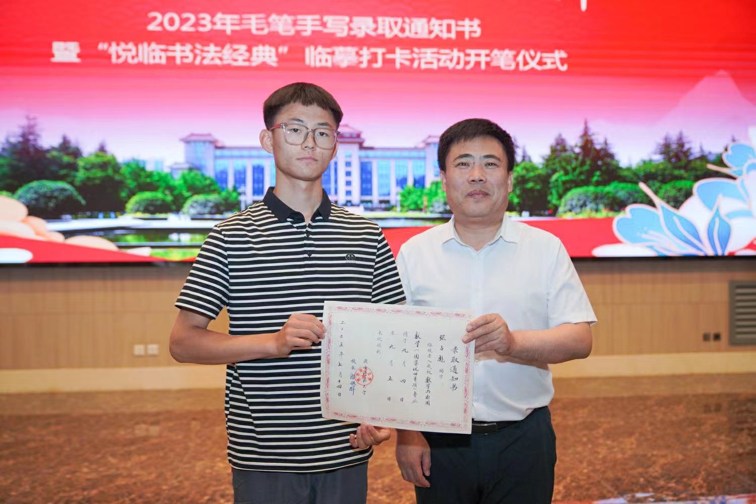 陜西師范大學(xué)黨委書記李忠軍為2023級新生代表張占彪同學(xué)發(fā)放錄取通知書。校方供圖