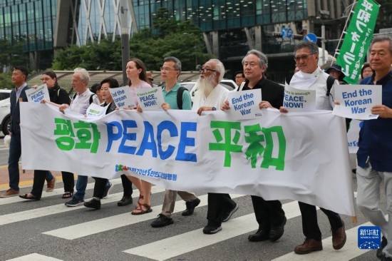 7月22日，在韓國首爾，人們手舉標(biāo)語參與反戰(zhàn)游行。新華社發(fā)（楊暢 攝）