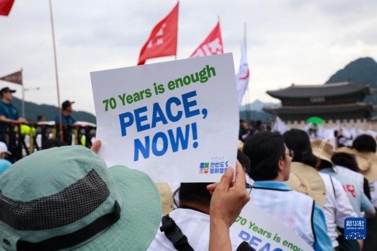 7月22日，在韓國首爾，人們手舉標(biāo)語參與反戰(zhàn)游行。新華社發(fā)（楊暢 攝）
