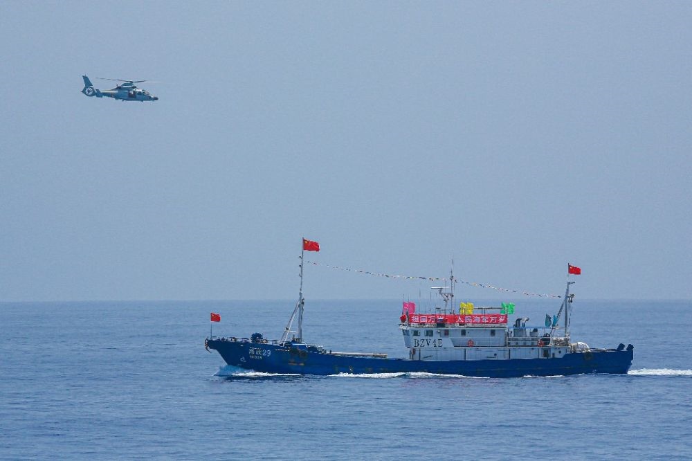 ↑中國海軍第40批護航編隊中的艦載直升機在被護船只周邊海域巡邏警戒（2022年6月4日攝）。新華社發(fā)（唐文 攝）