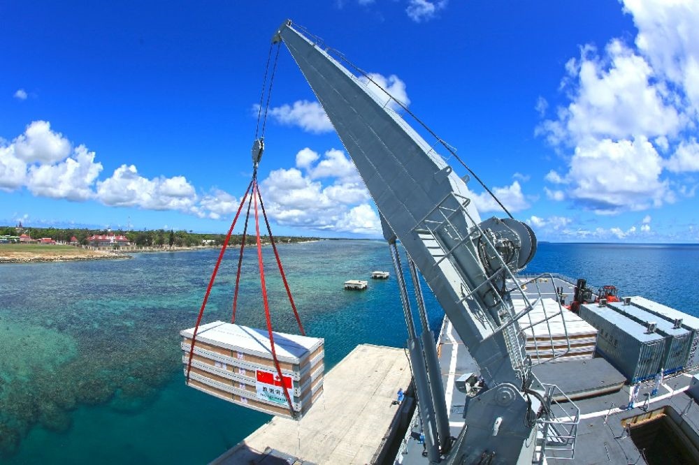 ↑赴湯加執(zhí)行運送救災物資任務的中國海軍艦艇編隊在努庫阿洛法港卸載移動板房（2022年2月19日攝）。新華社發(fā)（薛成清 攝）