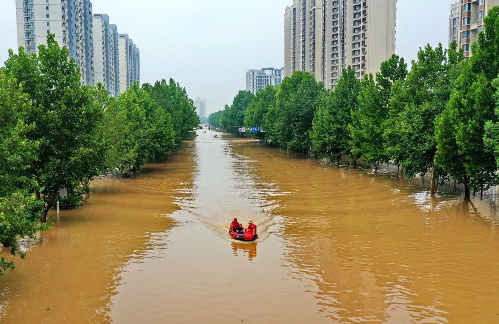 救援人員在河北省涿州市市區(qū)乘坐沖鋒舟前去轉(zhuǎn)移受災(zāi)群眾（8月2日攝，無(wú)人機(jī)照片）。新華社記者 牟宇 攝