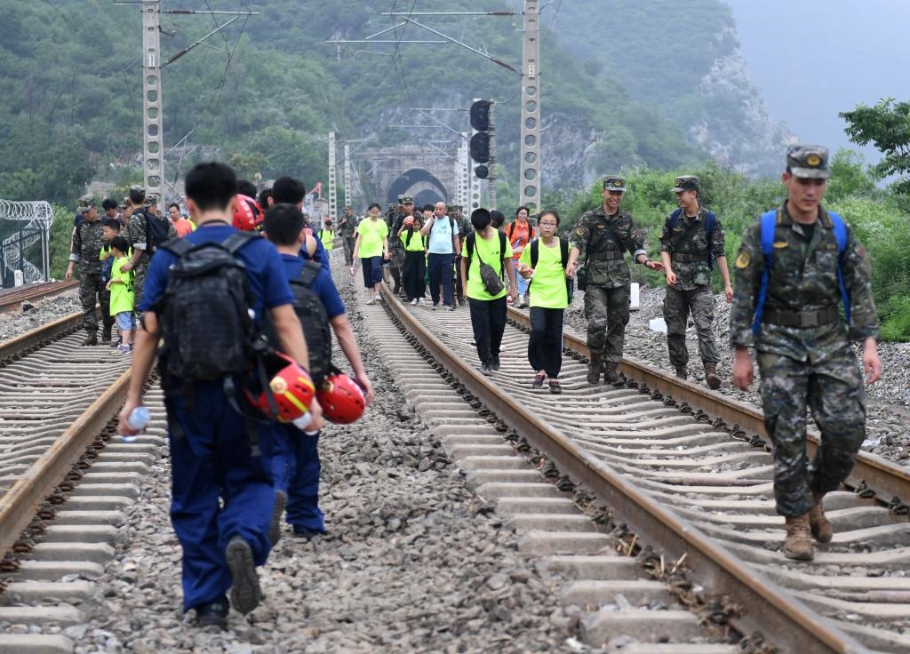 8月2日，部分滯留在北京市門頭溝山區(qū)受困列車的旅客，在救援人員幫助下前往轉(zhuǎn)運(yùn)客車。新華社記者張晨霖 攝