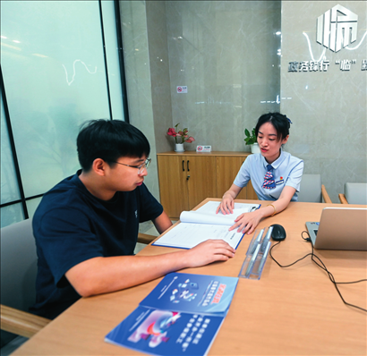 在杭州市臨安區(qū)政務(wù)服務(wù)中心的“為企服務(wù)中心”，黨員志愿者（右）解答企業(yè)主的疑問（2023年7月7日攝）。徐昱攝/本刊