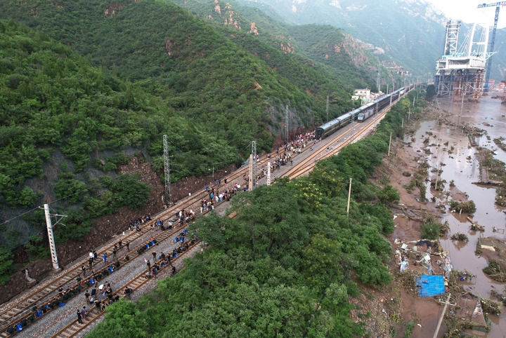 8月2日，受困列車(chē)旅客在救援人員幫助下徒步趕往轉(zhuǎn)運(yùn)客車(chē)（無(wú)人機(jī)照片）。新華社記者 張晨霖 攝