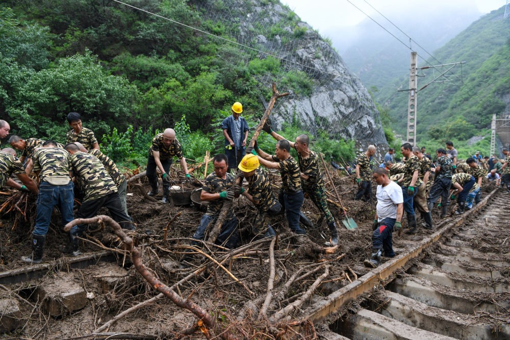 8月1日，在北京市門(mén)頭溝區(qū)水峪嘴村附近一段被阻斷的鐵路線上，中鐵六局工作人員在清理軌道上的雜物，全力恢復(fù)交通。新華社記者 鞠煥宗 攝