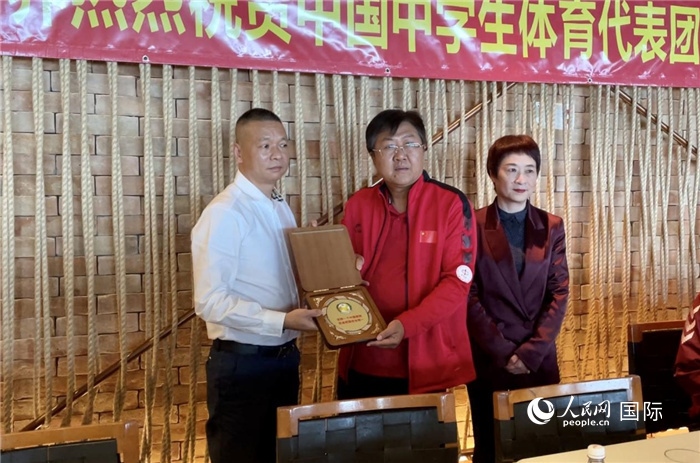 巴西中國和平統(tǒng)一促進會會長王俊曉向中國中學(xué)生體育代表團團長劉立新贈送紀(jì)念品。人民網(wǎng)記者 宋亦然攝