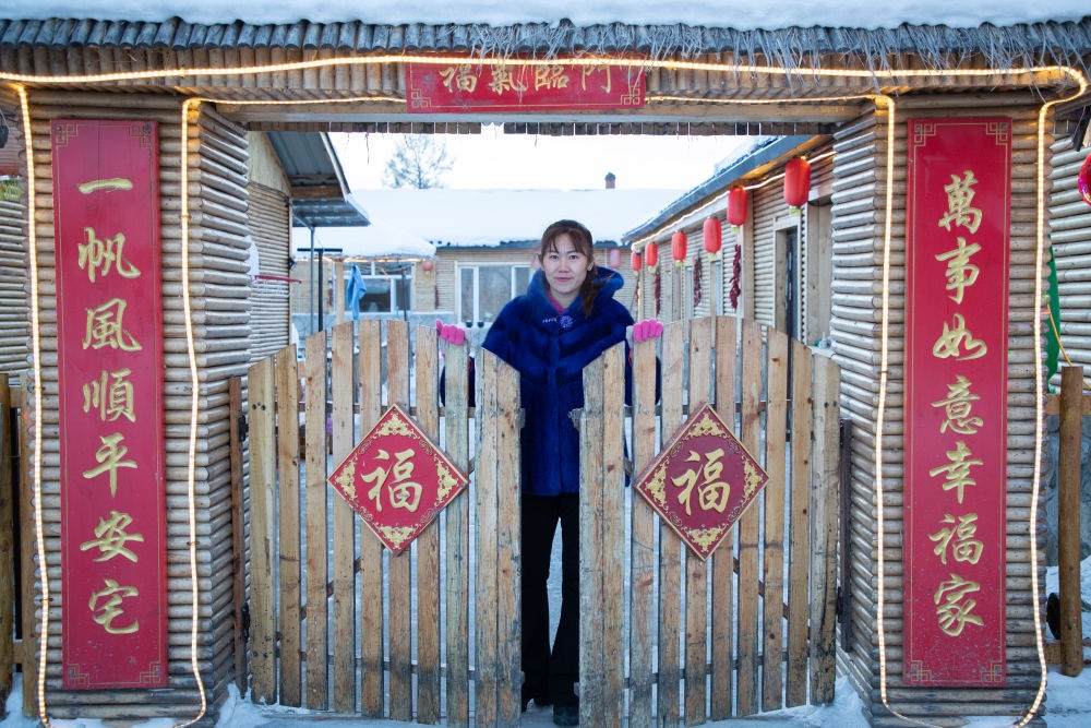 北極村民宿經(jīng)營者史瑞娟在門前迎候入住的游客（2023年1月7日攝）。