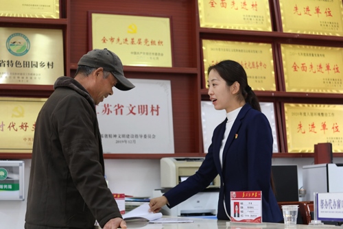 李敏在雙蕩村便民服務(wù)大廳接待前來辦理業(yè)務(wù)的村民。受訪者供圖