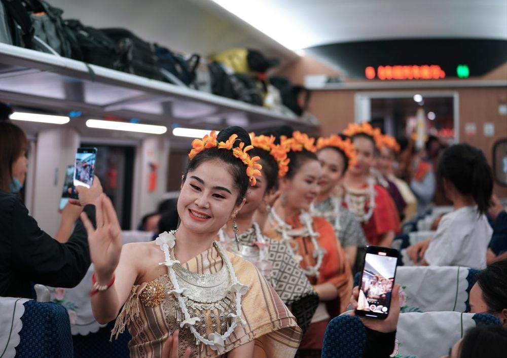 2023年4月13日，老撾工作人員在中老鐵路上開行的D887次國際旅客列車上表演。新華社記者 邢廣利 攝