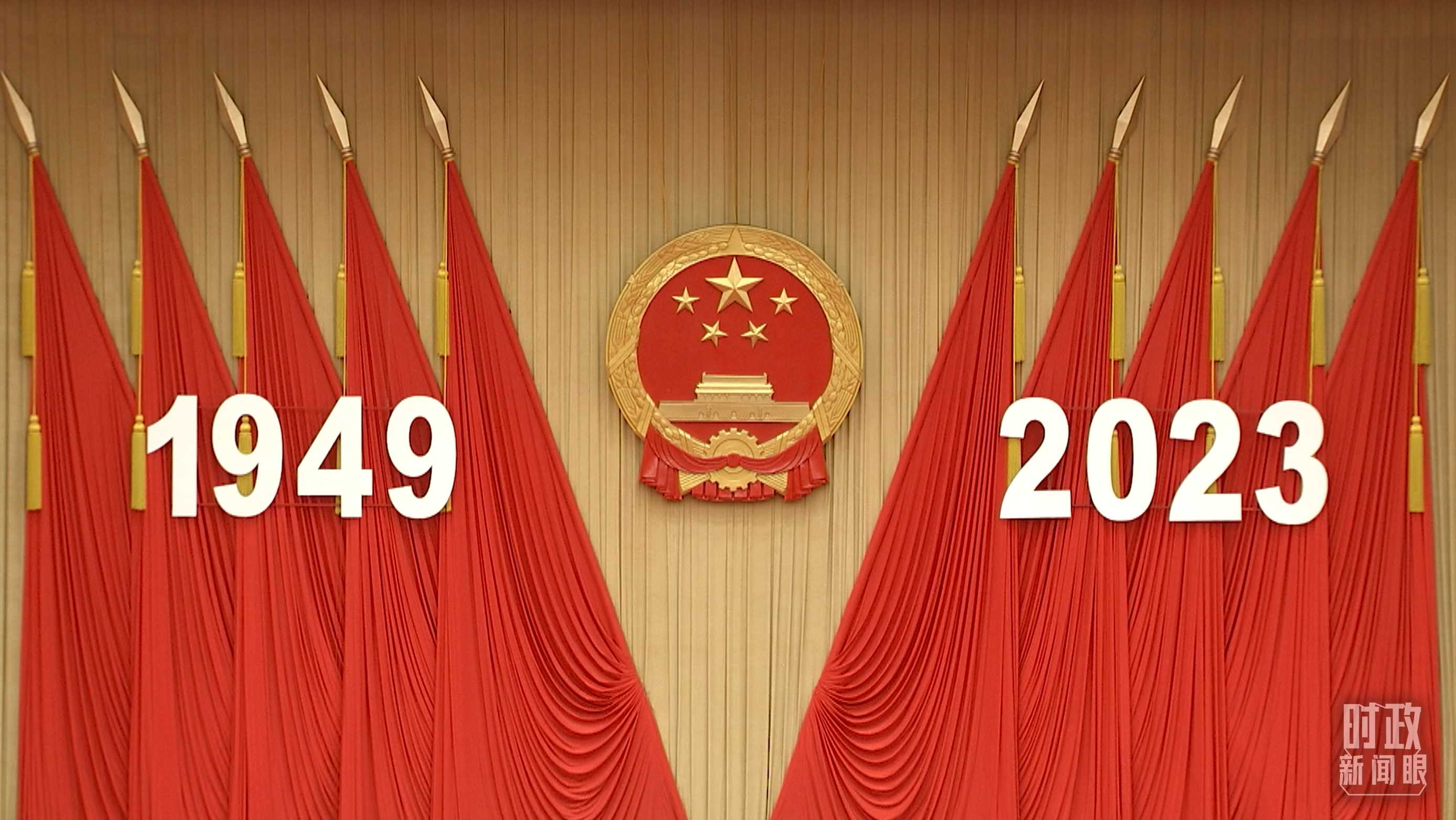 △人民大會堂宴會廳內(nèi)，主席臺上方高懸著莊嚴的國徽，“1949－2023”大字年號在鮮艷的紅旗映襯下格外醒目。