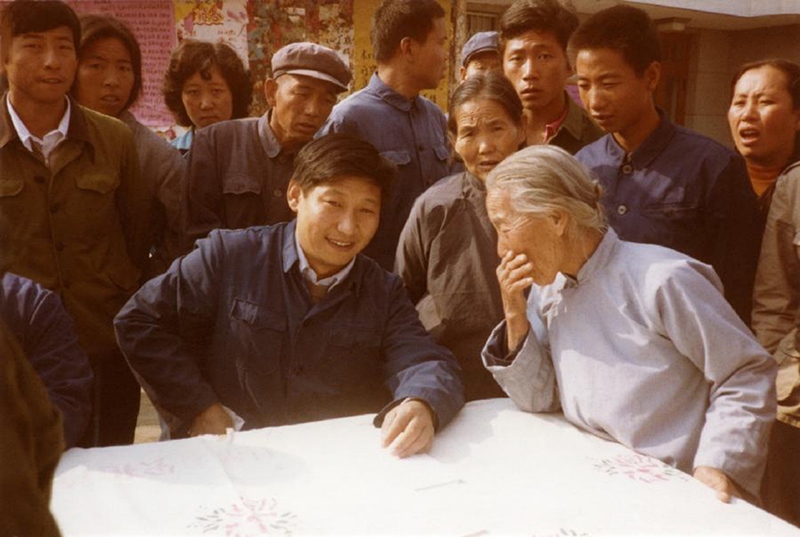 1983年，時(shí)任河北正定縣委書記的習(xí)近平（前排居中）臨時(shí)在大街上擺桌子聽取老百姓意見。