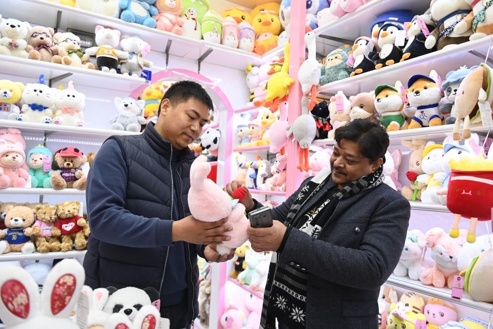 2023年2月2日，來(lái)自印度的客商（右）在義烏國(guó)際商貿(mào)城的一家玩具店鋪內(nèi)選購(gòu)商品。新華社記者 黃宗治 攝