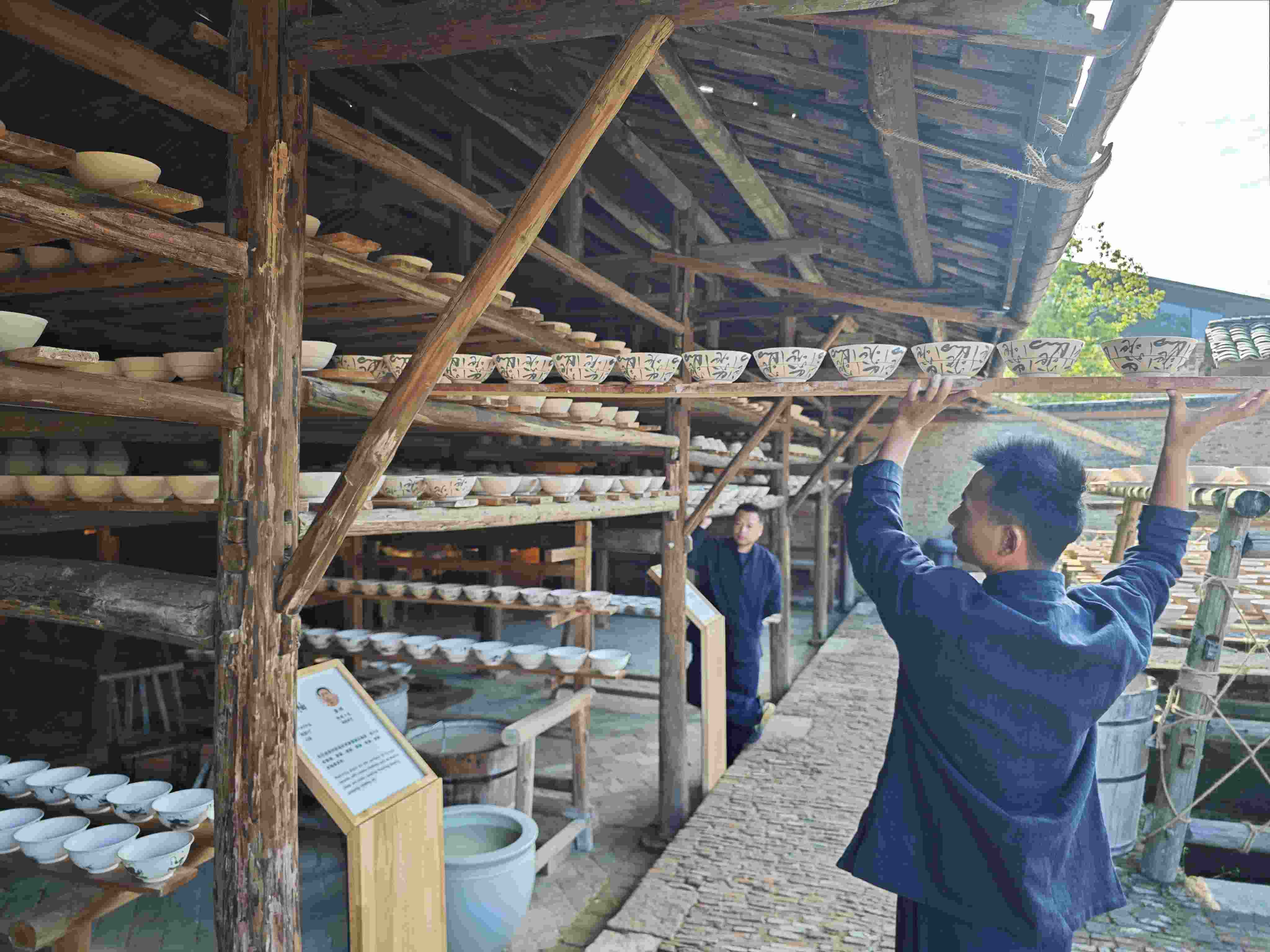 △陶陽(yáng)里歷史文化街區(qū)里，工匠將陶瓷工藝品放到架上晾干。（總臺(tái)央視記者彭漢明拍攝）