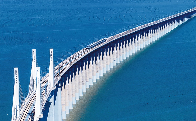 2023年9月28日，中國首條時速350公里跨海高鐵——福廈高鐵正式開通運營。圖為一列運行試驗車組駛過福廈高鐵湄洲灣跨海大橋（9月19日攝，無人機照片）。 新華社記者 魏培全/攝