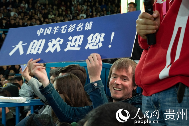 外媒記者舉起手牌為運(yùn)動(dòng)員加油。人民網(wǎng) 陽茜攝