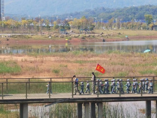 10月24日，秋游的幼兒園小朋友在老師帶領(lǐng)下走在清水塘公園里的木橋上。本報(bào)記者 常雯宜攝