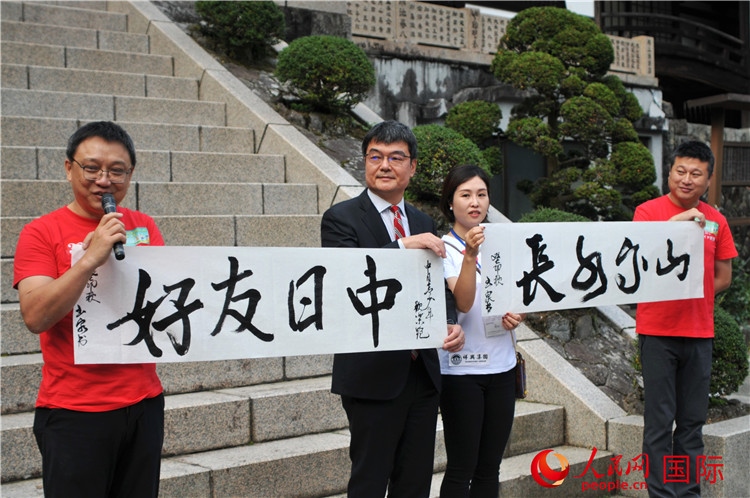 東京中國(guó)文化中心主任羅玉泉展示其為本次活動(dòng)書(shū)寫(xiě)的題詞“中日友好，山高水長(zhǎng)”。人民網(wǎng) 蔣曉辰攝