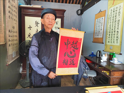 越南首都河內(nèi)文廟內(nèi)，阮明珠展示“中越心相近”書法作品。