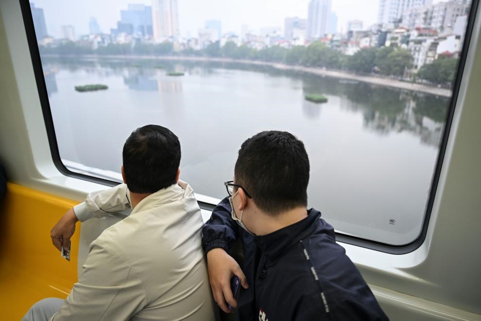 12月9日，市民在越南河內(nèi)輕軌二號線車廂內(nèi)透過車窗欣賞城市風(fēng)景。