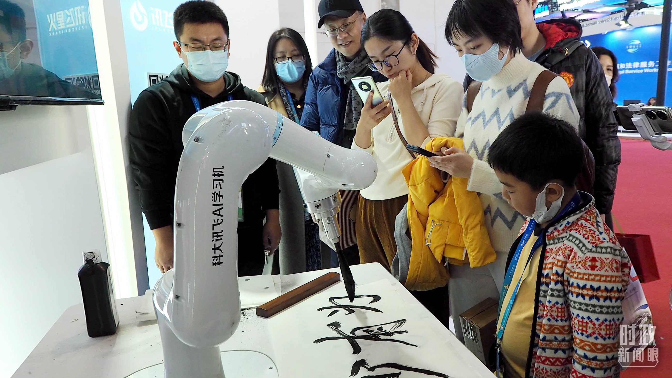 △觀眾在首屆鏈博會上體驗AI書法機器人。
