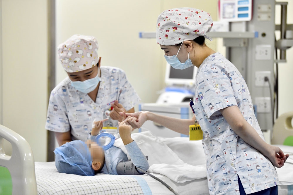 在山東省棗莊市婦幼保健院兒童ICU病房，醫(yī)護(hù)人員為完成靶向治療藥物諾西那生鈉的4歲脊髓性肌萎縮癥患兒加油鼓勁（2022年1月1日攝）。諾西那生鈉注射液是我國首個獲批治療脊髓性肌萎縮癥的進(jìn)口藥物，2019年進(jìn)入中國市場時，每針價格近70萬元。在2021年國家醫(yī)保目錄藥品談判中，以3.3萬元每針的價格進(jìn)入新版醫(yī)保藥品目錄。新華社記者 郭緒雷 攝